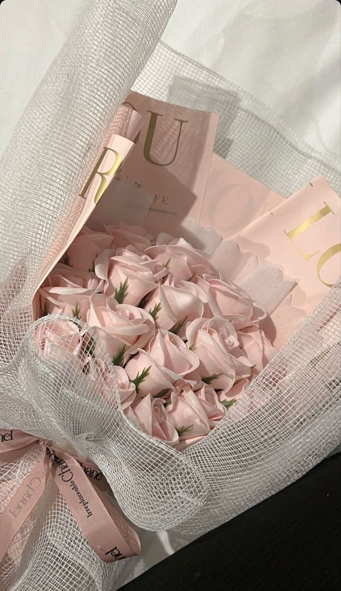 a bouquet of pink roses wrapped in white mesh