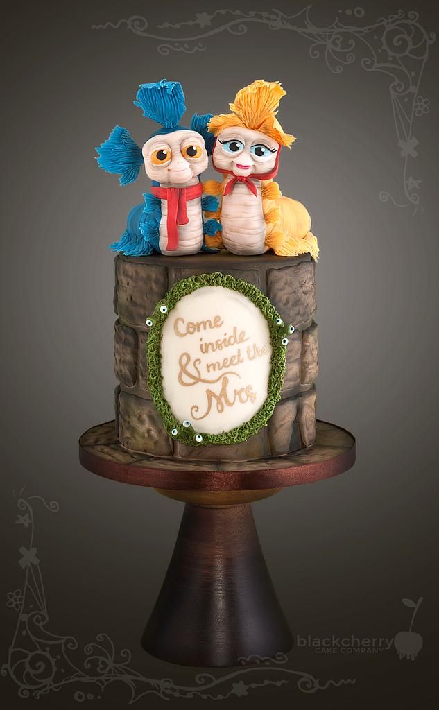 there is a cake that has three small figurines on it