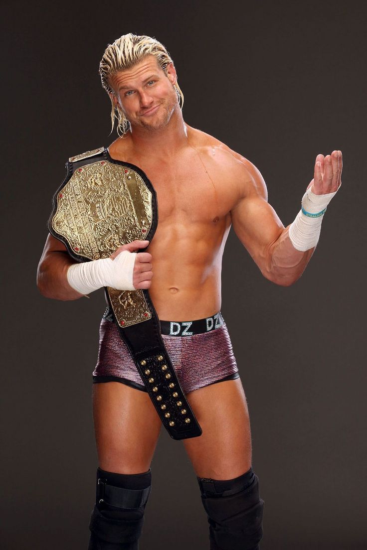 a man in wrestling gear posing for a photo with his hand on his hip and holding a