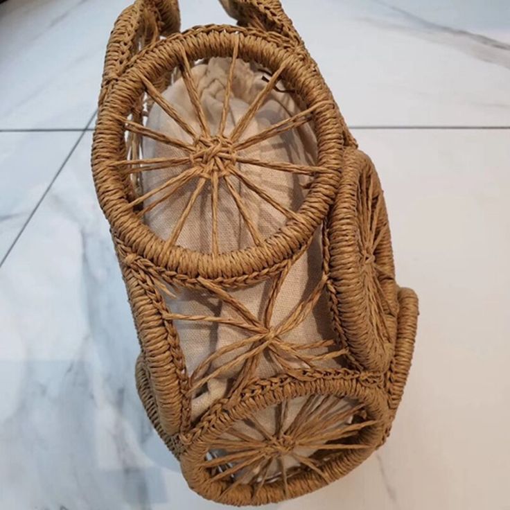 a wicker purse sitting on top of a marble floor