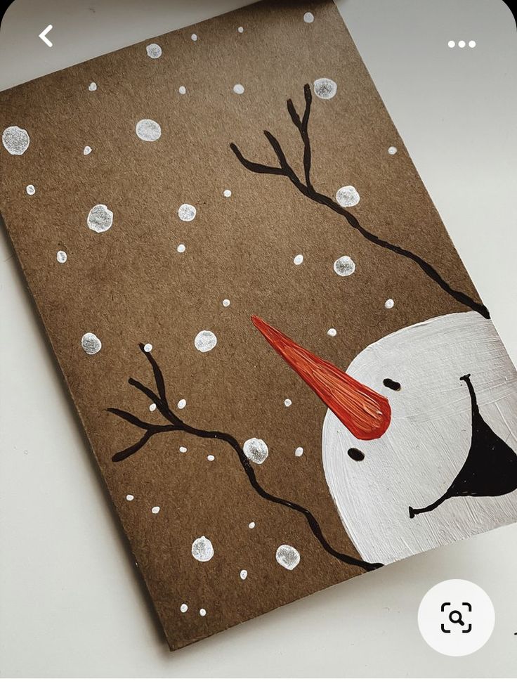 a brown card with a white snowman and red hat on it's head