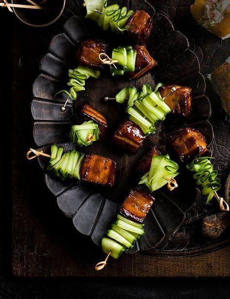 some food is sitting on a plate with chopsticks and other foods around it