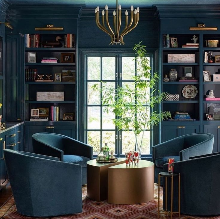 a living room filled with blue furniture and bookshelves in front of a window