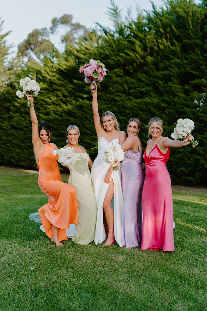 the bridesmaids are holding their bouquets in the air and posing for a photo