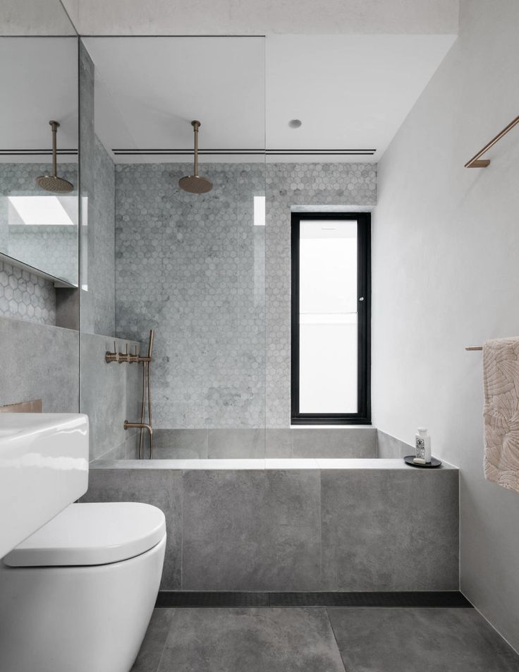 a bathroom with a toilet, sink and bathtub next to a window in the wall