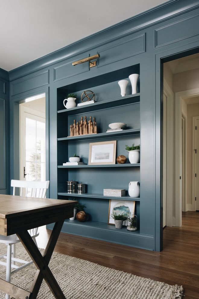 a dining room with blue walls and shelves