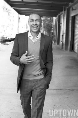 a black and white photo of a man walking down the street with his hand in his pocket