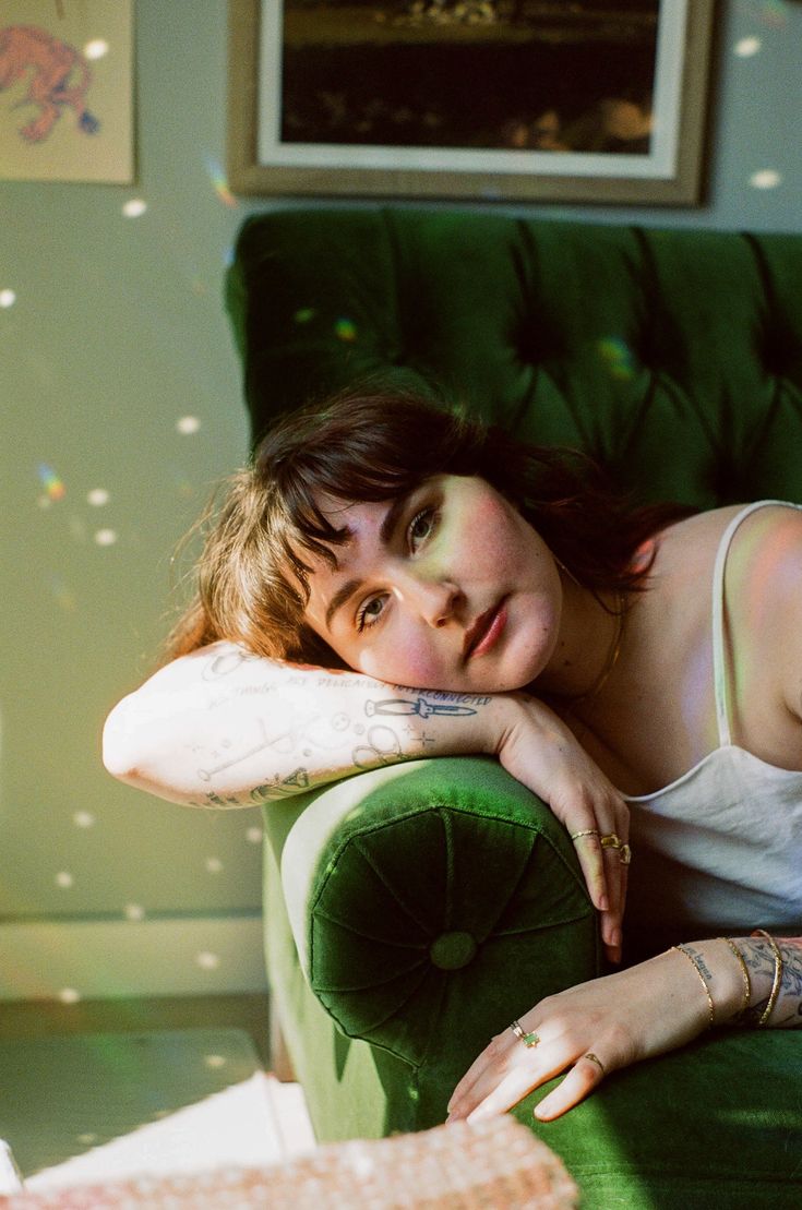 a woman sitting on top of a green chair