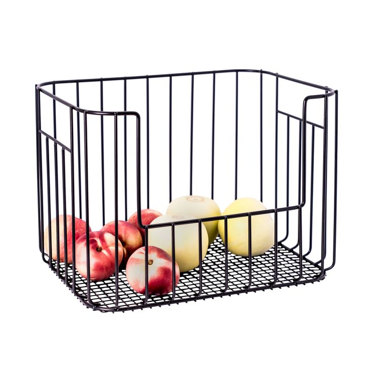 some apples are sitting in a wire basket