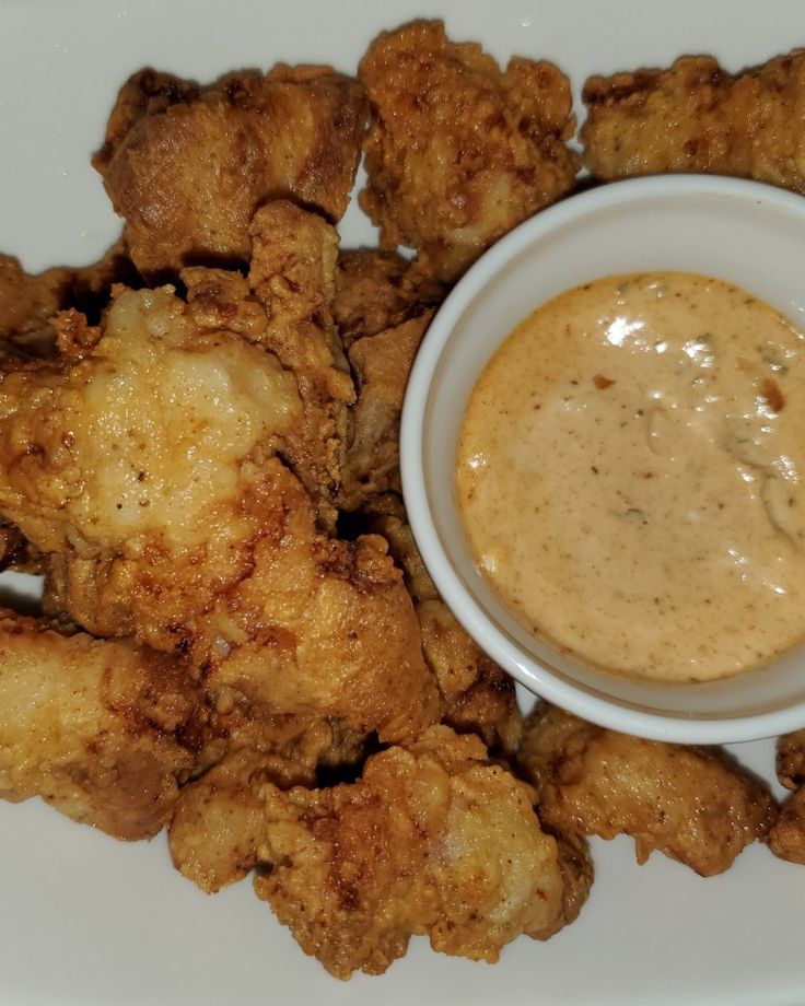 fried chicken with dipping sauce on a white plate