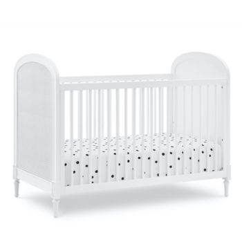 a white crib with black dots on it