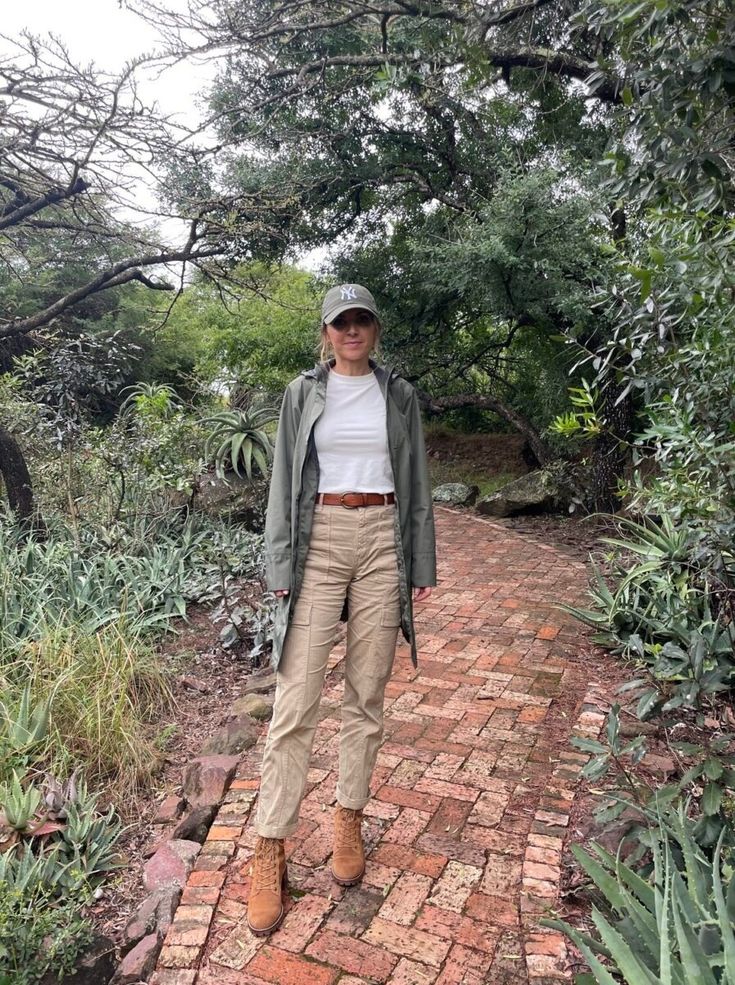 a woman is standing on a brick path