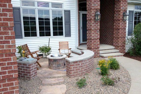 a patio with chairs and fire pit in front of a house