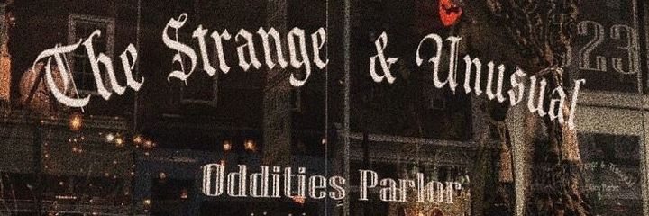 the strange and unusual oddities parlor sign in front of a building at night time