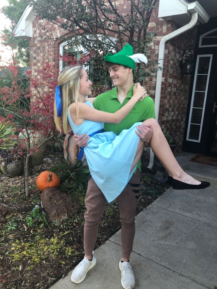 two people dressed up as peter pan and the lepreti man are standing in front of a house