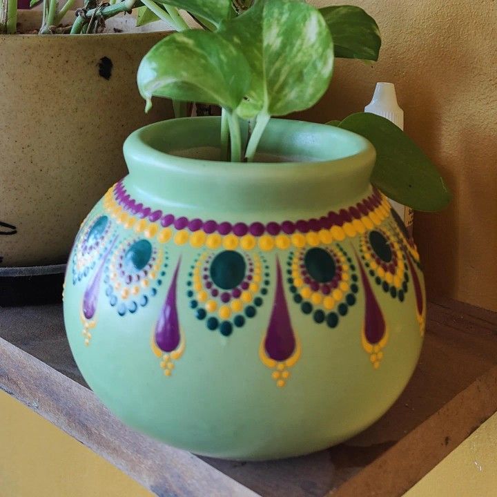 a potted plant sitting on top of a shelf next to a potted plant