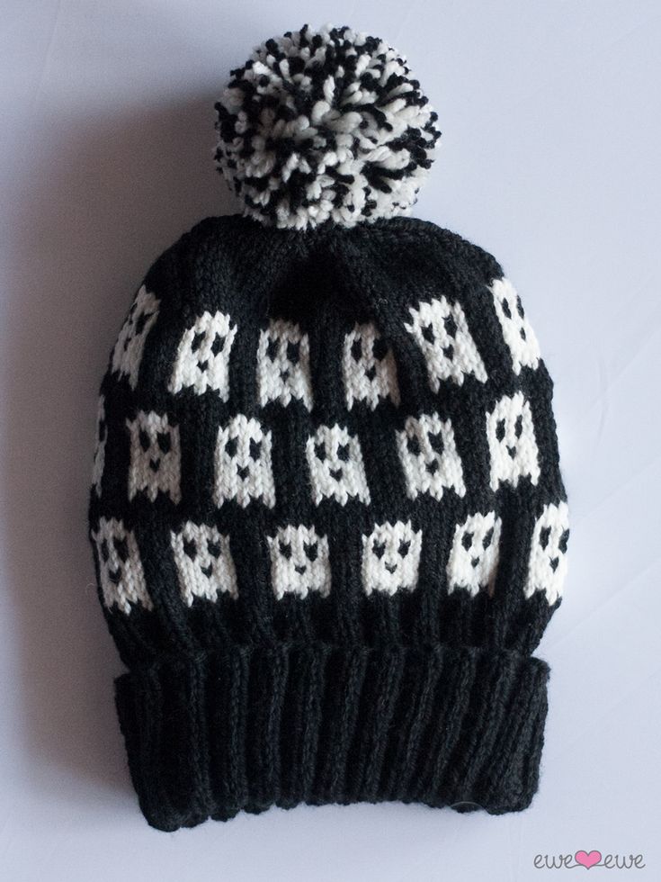 a black and white knitted hat with skulls on it