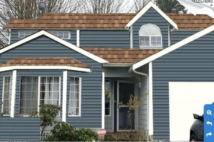 a blue house with white trim and brown roof