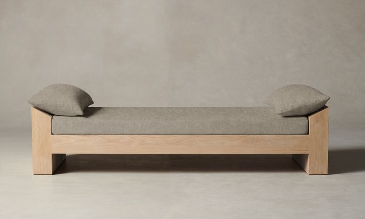 a wooden bench with two pillows on it's back and one pillow on the top