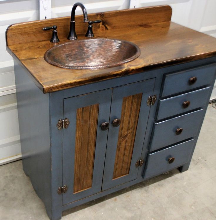 a bathroom sink sitting on top of a wooden counter next to a white wall and door