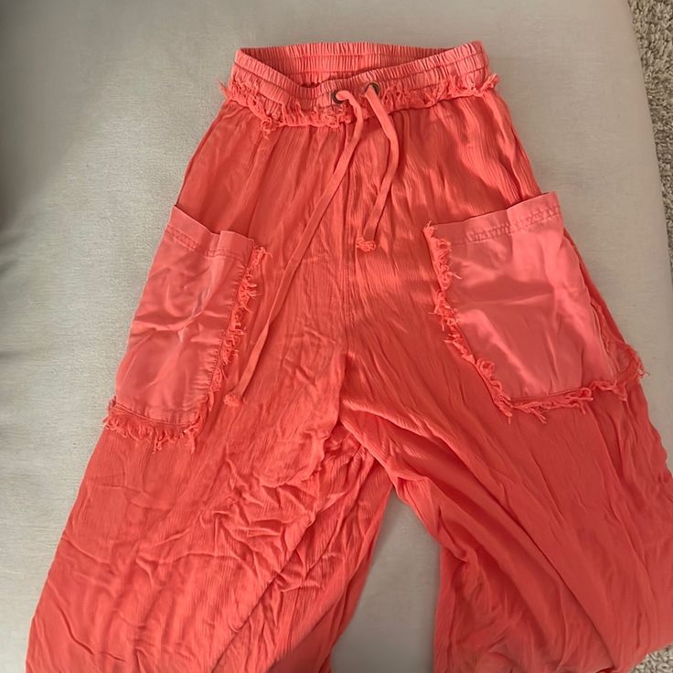 Free People Movement Pants -Size: Xs -Bright Coral Pink -Fringe Detail / 2 Front Pockets/ Flare Legs -Only Tried On Never Worn Summer Vacation Parachute Pants With Pockets, Summer Beach Parachute Pants With Pockets, Summer Parachute Pants With Pockets, Spring Beach Parachute Pants With Pockets, Wide Leg Bottoms With Cargo Pockets For Vacation, Spring Wide Leg Bottoms With Fringe, Pink Parachute Pants With Side Pockets For Summer, Summer Pink Parachute Pants With Elastic Waistband, Bohemian Bottoms With Side Pockets For Spring