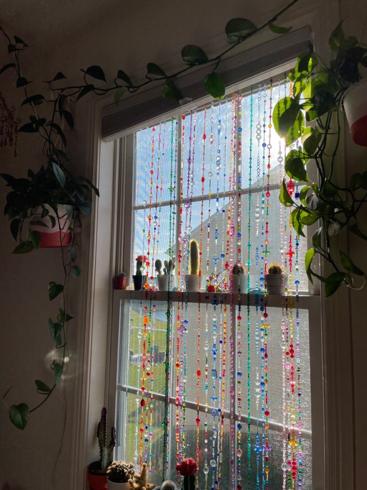 the window is decorated with beads and plants