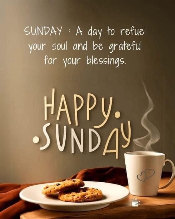 a cup of coffee and cookies on a table with the words happy sunday written in white