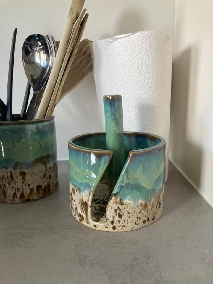 two cups with spoons and utensils in them sitting on a counter top