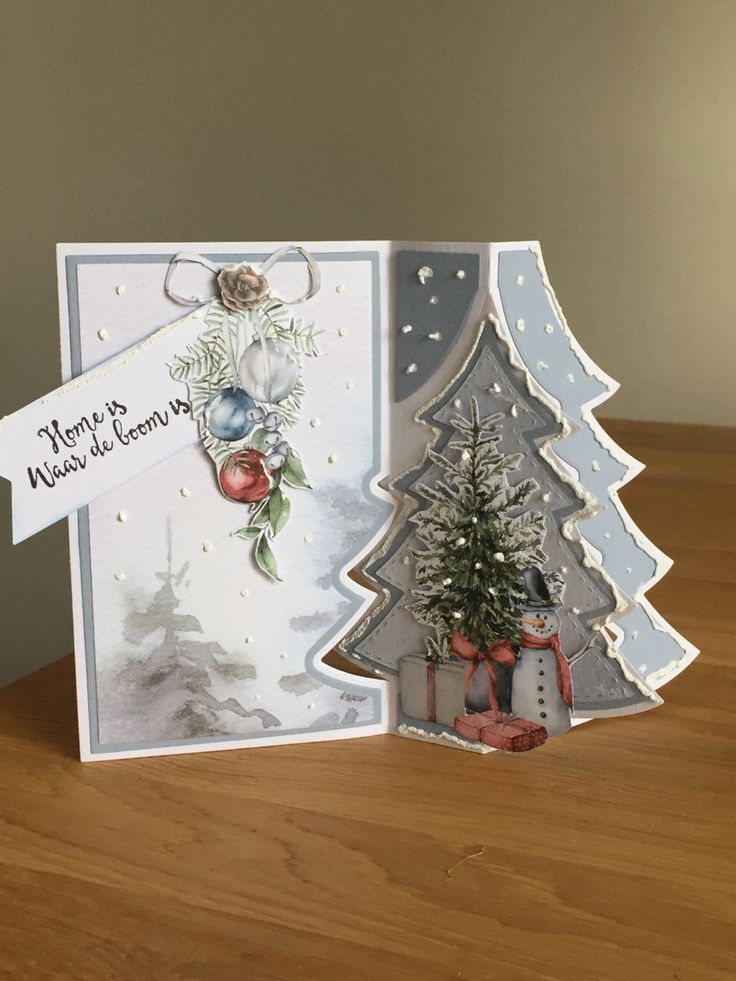 a christmas card with a tree and presents on the table next to it is an ornament that says merry christmas