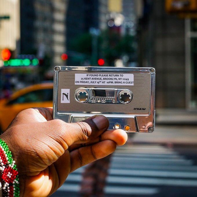 a person holding up an old fashioned cassette player