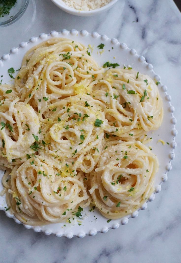 a white plate topped with pasta covered in sauce and parmesan sprinkles