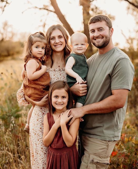 a family posing for a photo in the woods