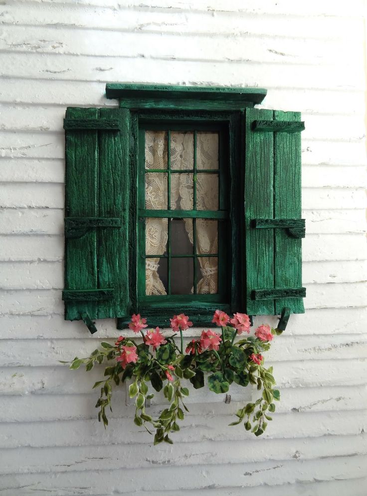 an old window with green shutters and potted flowers