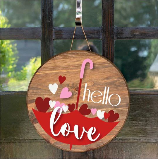 a wooden sign that says hello love with hearts and an umbrella hanging from the front door