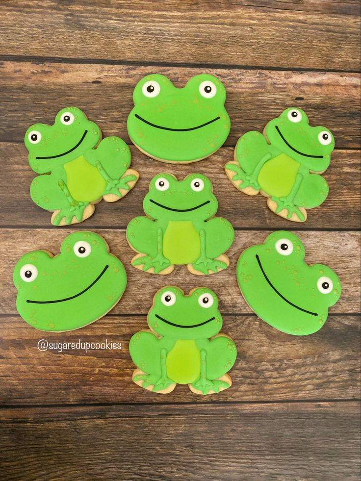 frog cupcakes with green frosting and eyes on wooden background, ready to be eaten