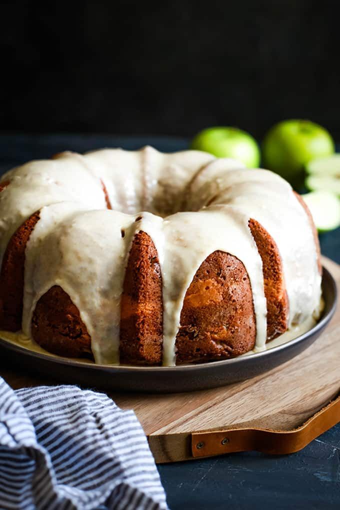 an apple cream cheese bundt cake on a wooden cutting board