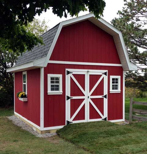 a red and white barn sitting in the grass