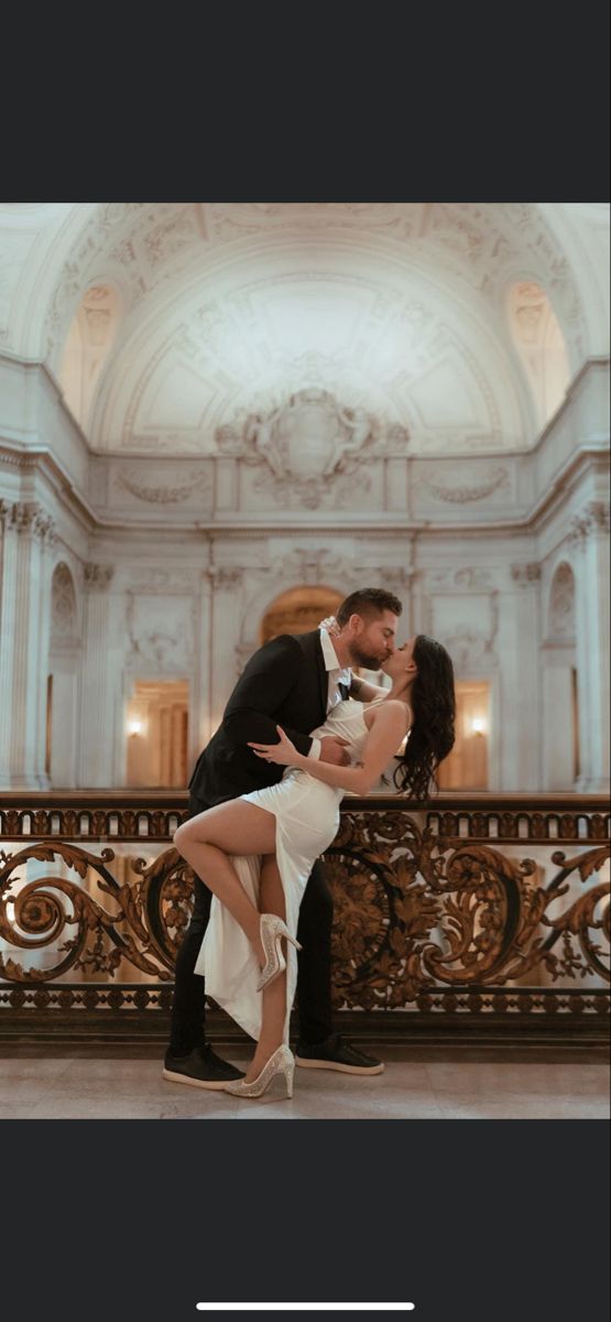 a man and woman are dancing in front of a balcony with chandeliers on it