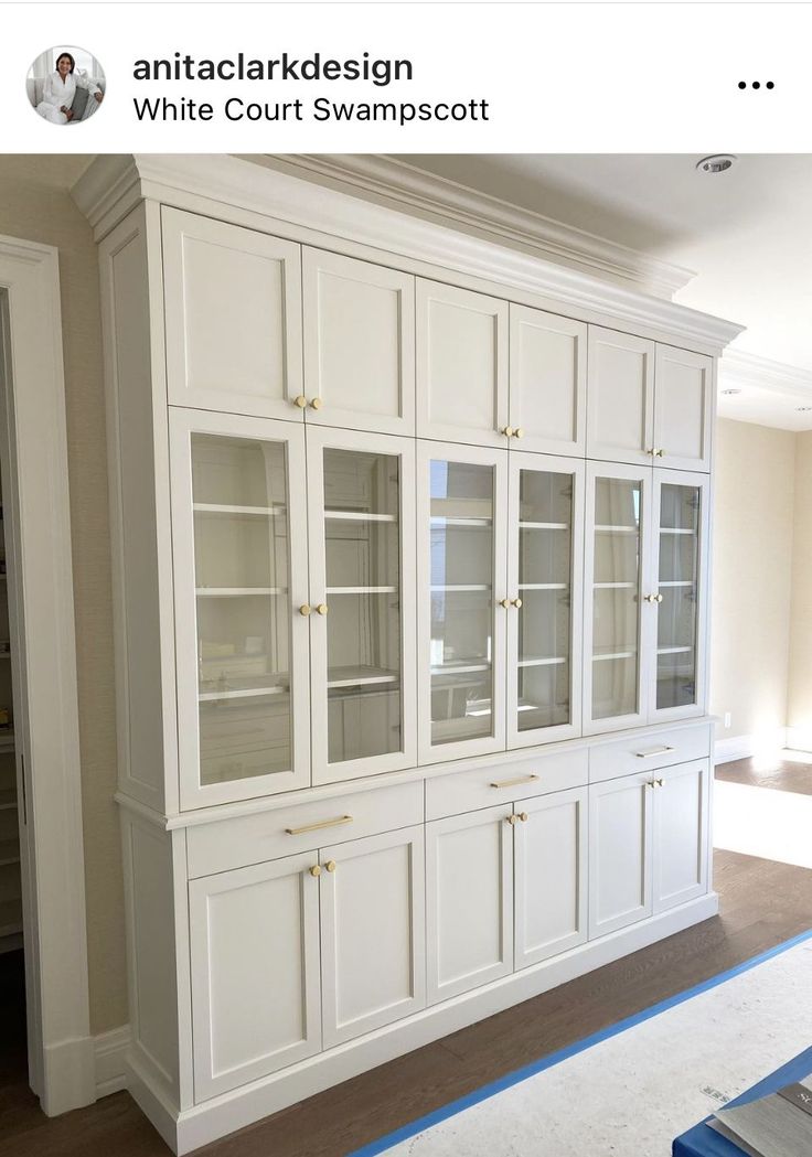 an empty room with white cabinets and blue tape on the floor in front of it