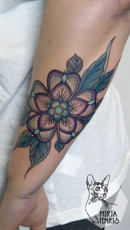 a woman's arm with a flower tattoo on the left side of her arm