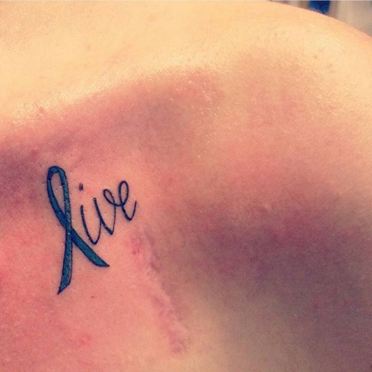 a woman's chest with a tattoo that says live