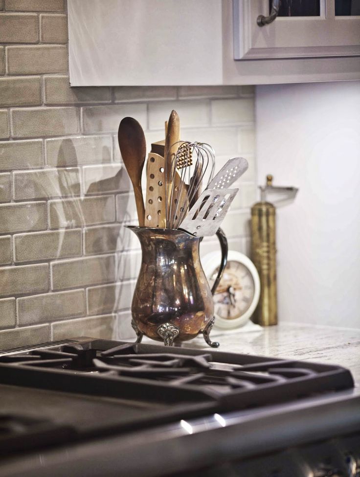 kitchen utensils in a pitcher on the stove