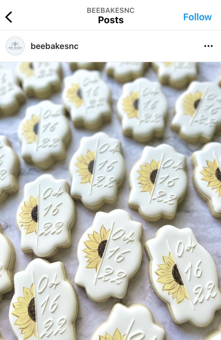 sunflower decorated cookies with white frosting and gold trimmings are displayed on a table