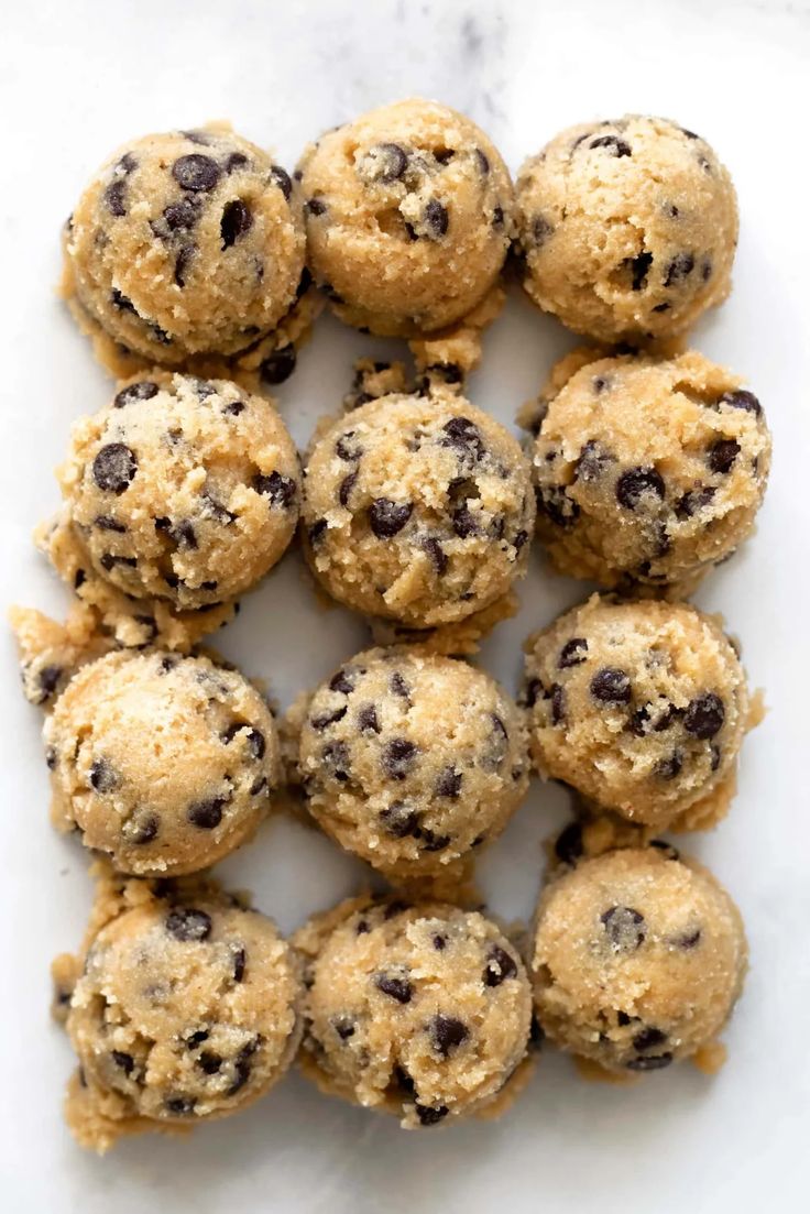 chocolate chip cookies are arranged on a white surface