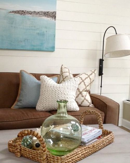 a living room with a couch, coffee table and painting on the wall behind it