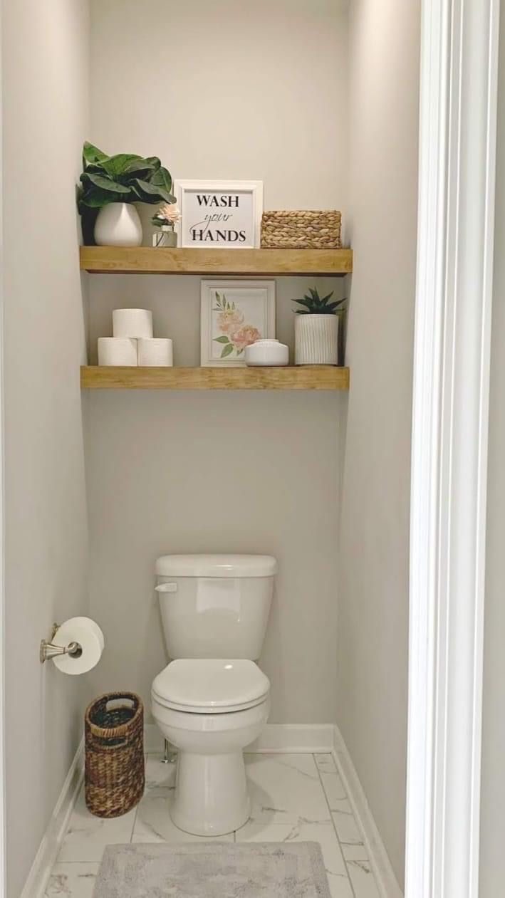 a white toilet sitting in a bathroom next to a wooden shelf