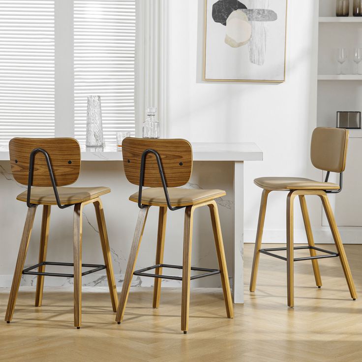 two wooden chairs sitting next to each other in front of a white table and bookshelf