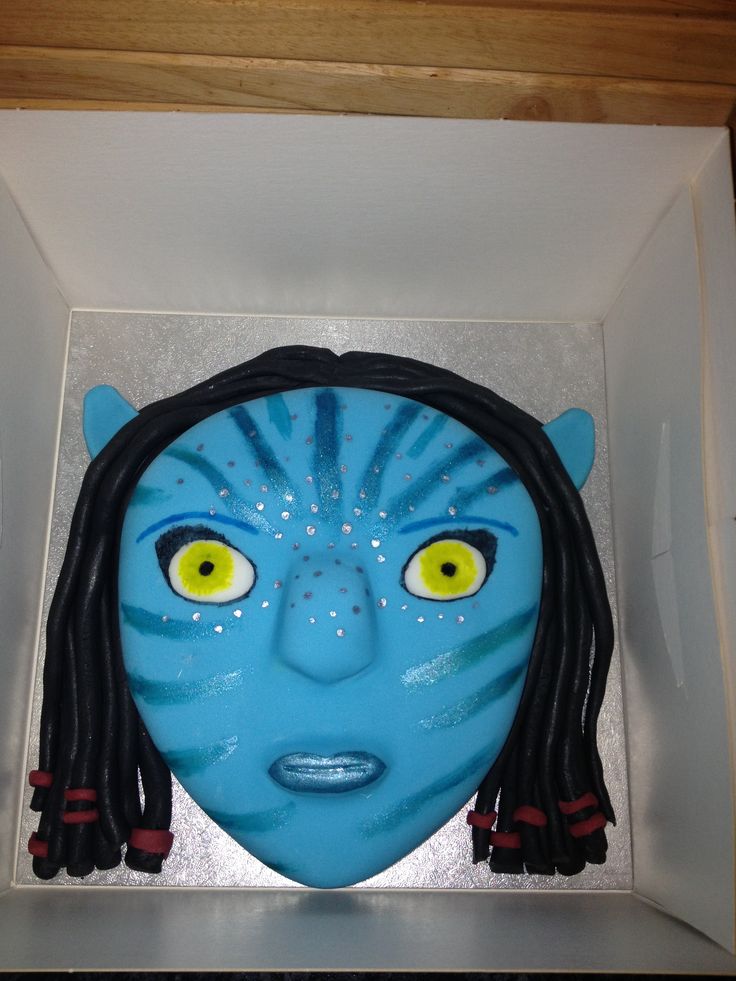 a blue mask with yellow eyes in a white box