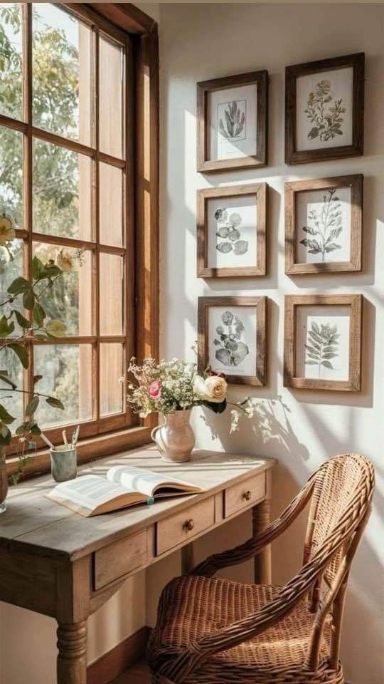 a desk and chair in front of a window with pictures on the wall above it