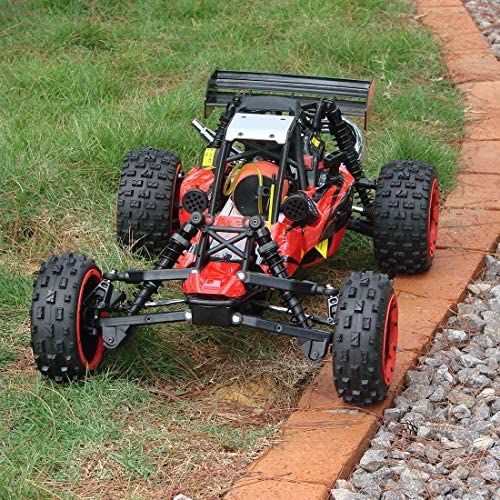 a red and black remote controlled buggy sitting on top of a brick walkway in the grass